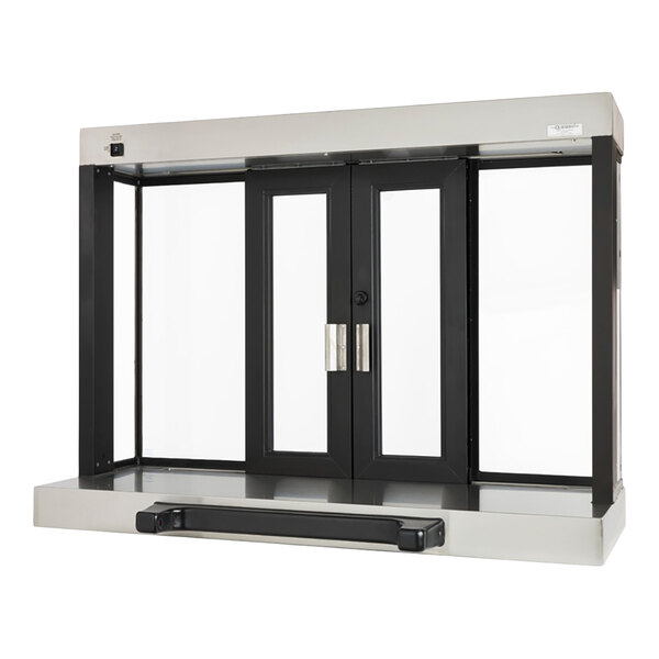 A stainless steel and glass automatic drive-thru window with black framing and dual sliding doors.