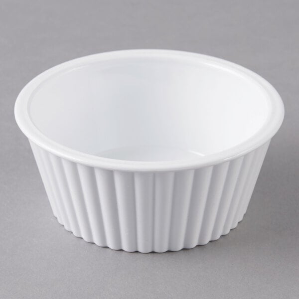 A white fluted Carlisle ramekin on a gray surface.