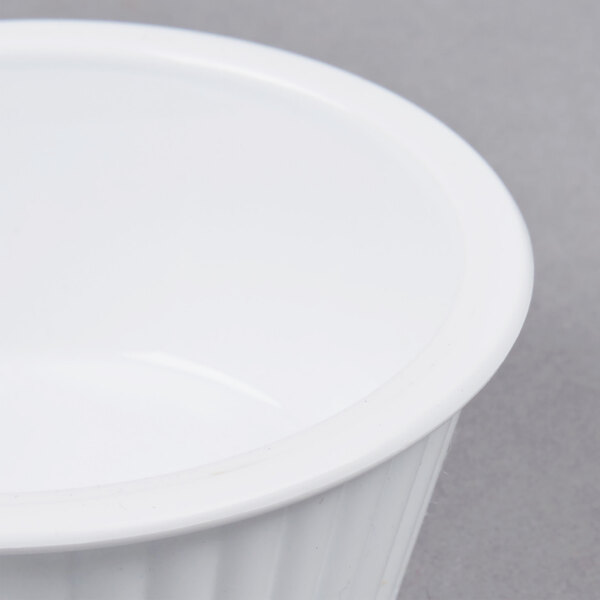 A close up of a white Carlisle fluted plastic ramekin.