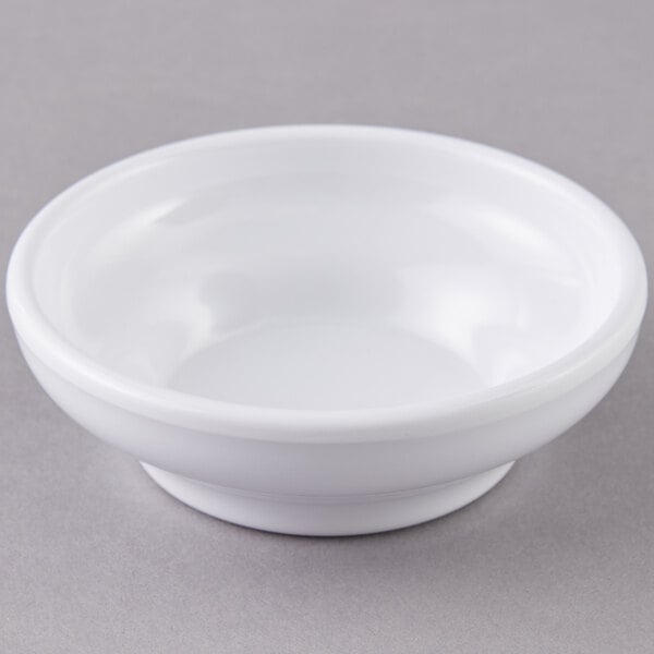 A white Carlisle salsa bowl on a gray surface.