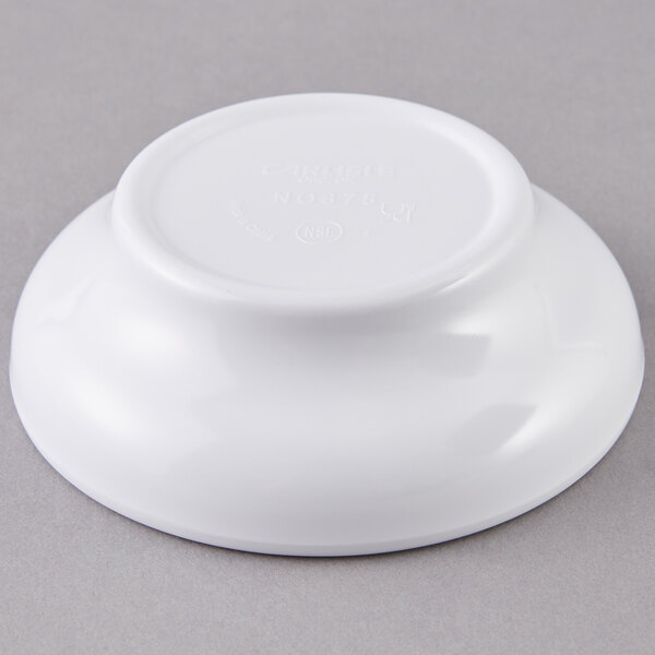 A Carlisle white salsa bowl on a gray surface.