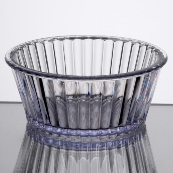 A clear Carlisle fluted plastic ramekin with a rim on top.
