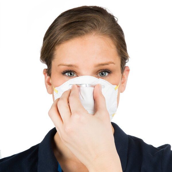 A woman wearing a Cordova N-95 valved particulate respirator over her mouth.