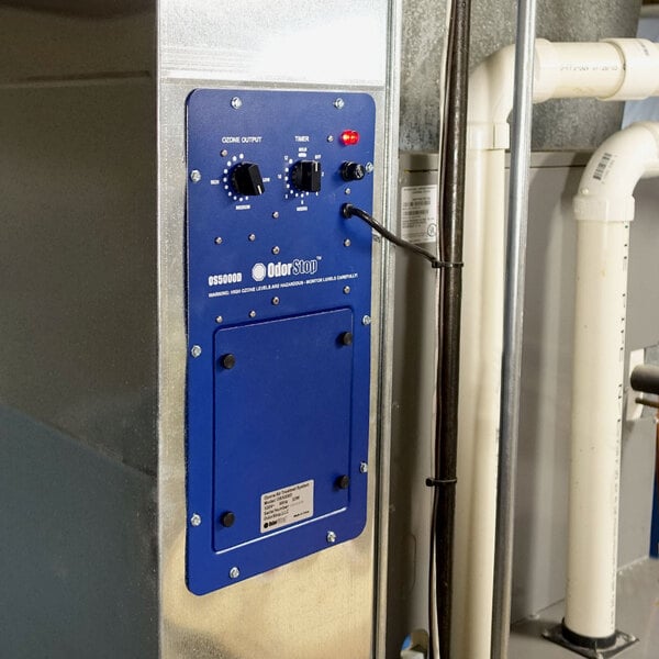 An OdorStop OS5000D duct-mounted ozone generator air purifier with a blue control panel and adjustment knobs.