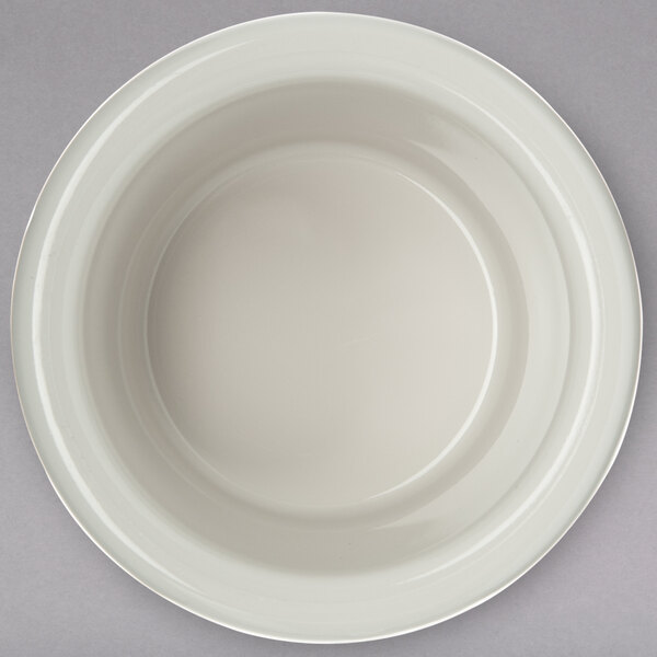 A Carlisle bone white plastic ramekin on a gray background.