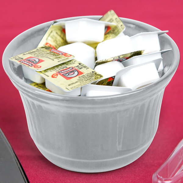 A Tablecraft gray cast aluminum bowl filled with white and yellow marshmallows.