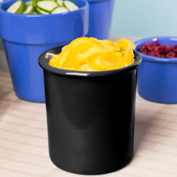 A black Tablecraft cast aluminum container with yellow food inside.