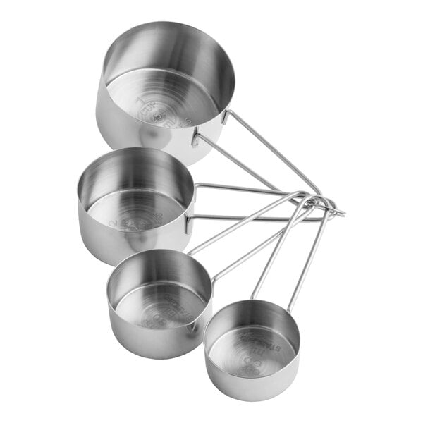 A set of four stainless steel measuring cups with wire handles.