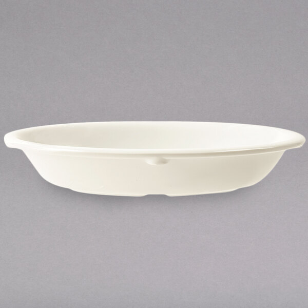 A close up of a white oval side dish.