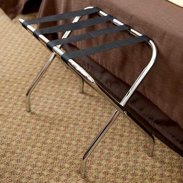 A CSL metal folding luggage rack with black straps on it.