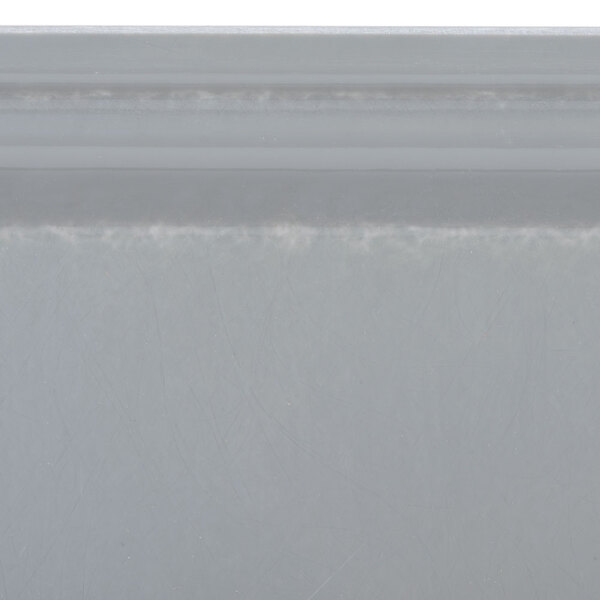 A close-up of a white surface with a gray rectangular tray on it.