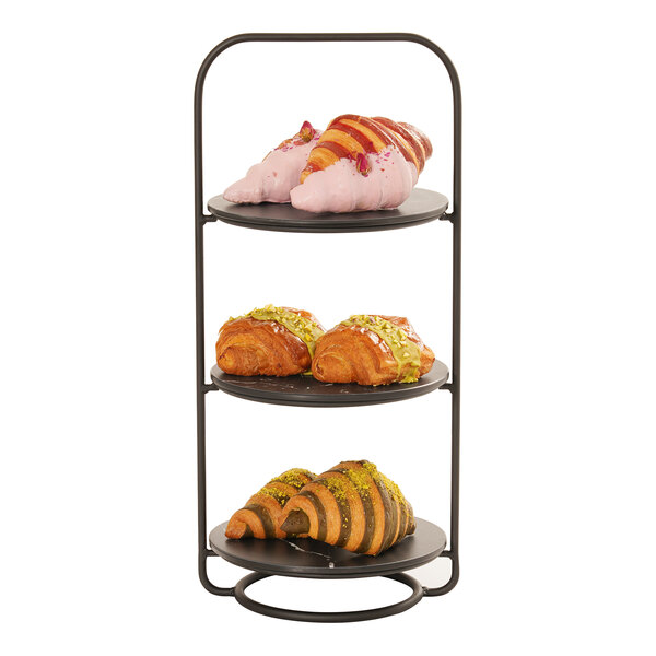 A three-tier metal plate stand holding assorted pastries on each level.
