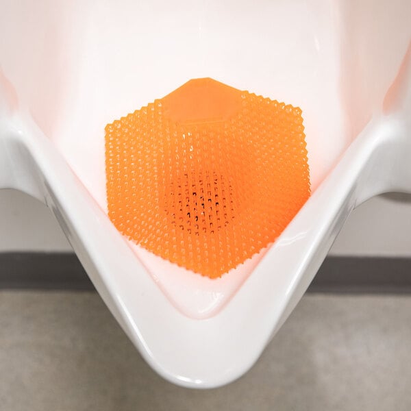 An orange EVA gel urinal screen with a mango scent placed inside a white urinal.
