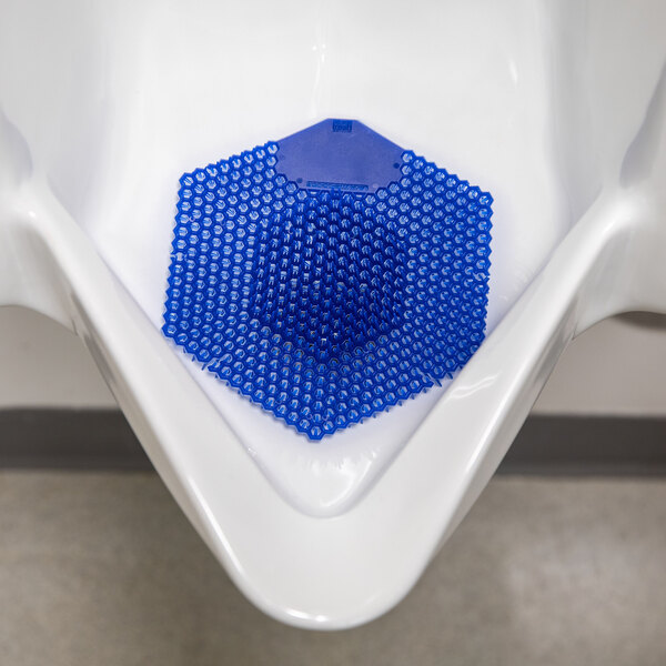 A blue EVA gel urinal screen with a cotton blossom scent placed inside a white urinal.