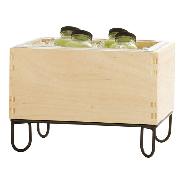 A wooden ice housing container with a metal stand, holding bottles on ice.
