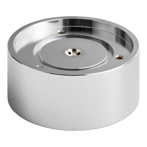 A round, metallic, chrome-colored component with a recessed center and a small hole in the middle, likely a mechanical or machine part.