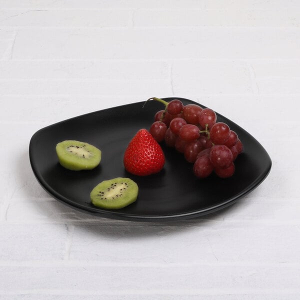 A black Elite Global Solutions square melamine plate with a kiwi on it.