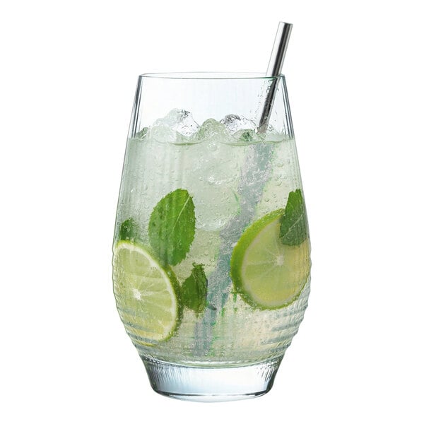 A clear highball glass filled with a lime and mint beverage, ice, and a metal straw.