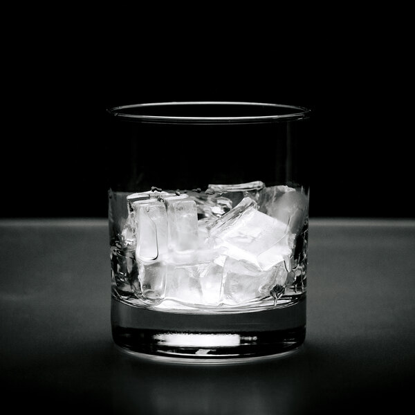 A clear glass filled with medium-sized ice cubes.