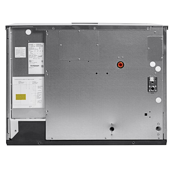 A commercial ice machine unit with a metal back panel and visible service labels.