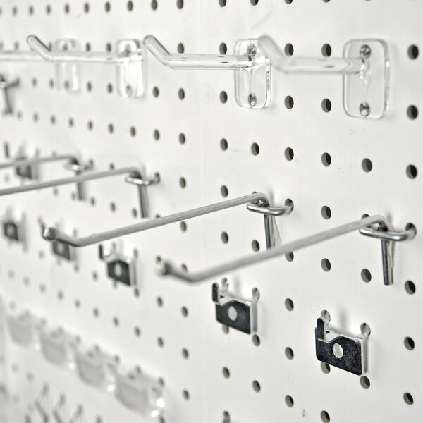 A set of metal hooks and accessories attached to a white pegboard.