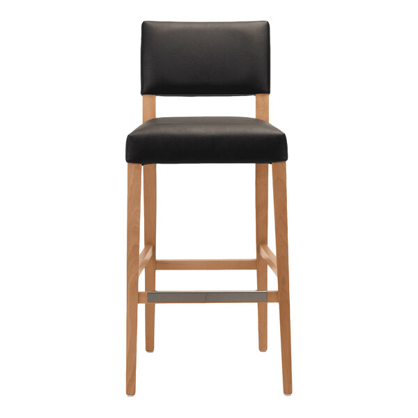 A bar stool with a natural beech wood frame and a black faux leather seat and backrest.