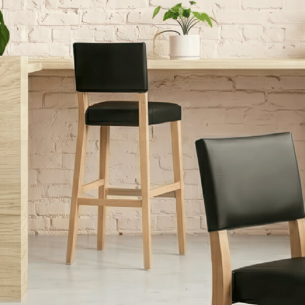A natural beech wood bar stool with a black faux leather seat and back.