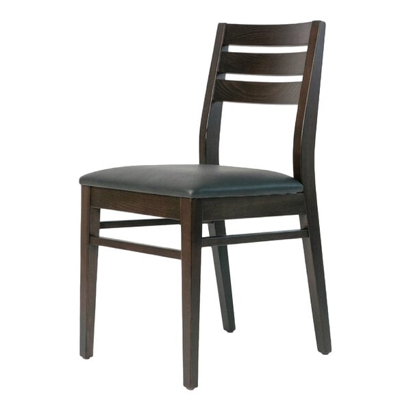 A dark brown beech wood dining chair with a ladder back design and a black faux leather seat.