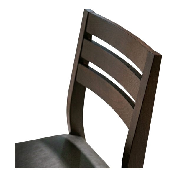 A dark brown beech wood dining chair with a ladder back design and a black faux leather seat.