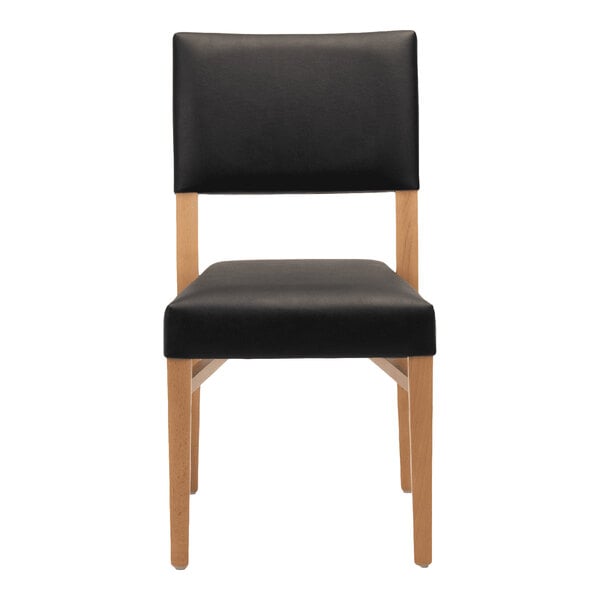 A stackable chair with a natural beech wood frame and black faux leather seat and back.