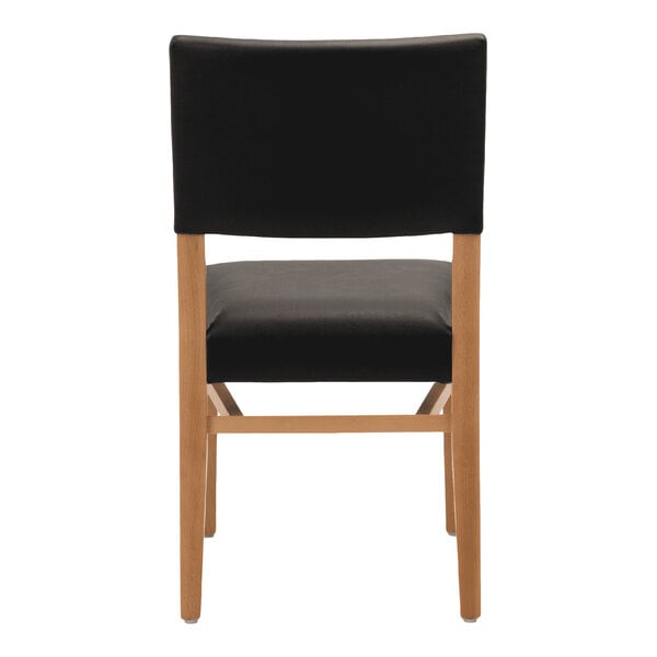 A stackable chair with a natural beech wood frame and black faux leather seat and backrest.