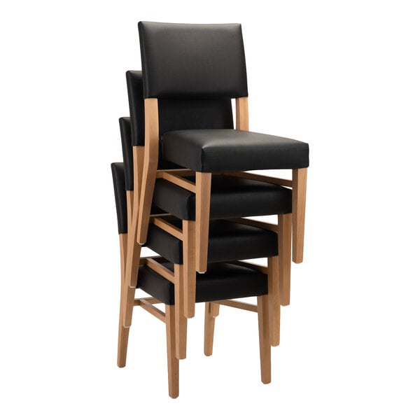 A stack of four natural beech wood chairs with black faux leather seats and backs.