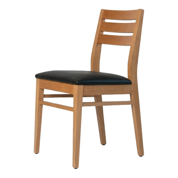 A natural beech wood dining chair with a ladder back design and a black faux leather seat.