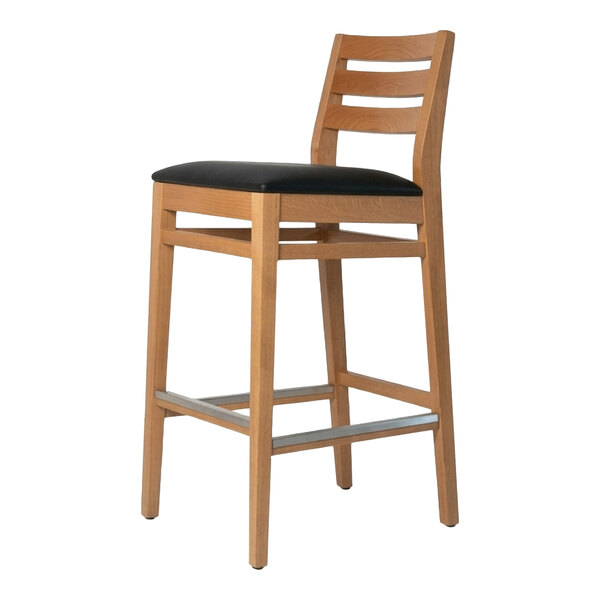 A natural beech wood bar stool with a ladder back design and a black faux leather seat.