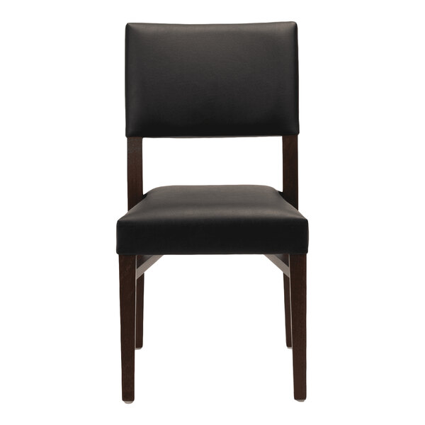 A dark brown beech wood stackable chair with a black faux leather seat and back.