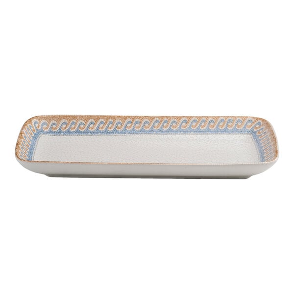 A rectangular white porcelain platter with a blue and tan wave design along the rim.
