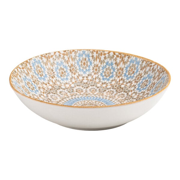 A round porcelain deep coupe plate with a blue and orange radial geometric design on the interior.