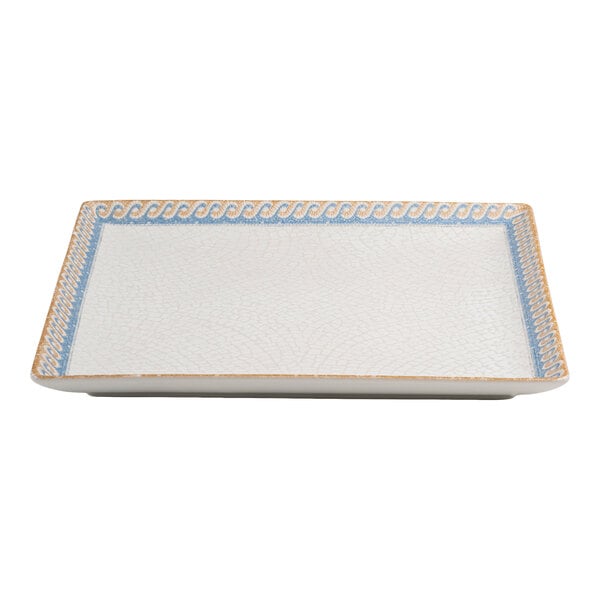 A square white porcelain plate with a blue and tan wave design along the border.