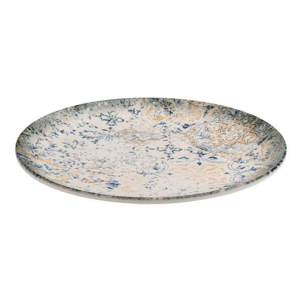 A round blue and white porcelain flat coupe plate with tan accents and an organic foliate design.