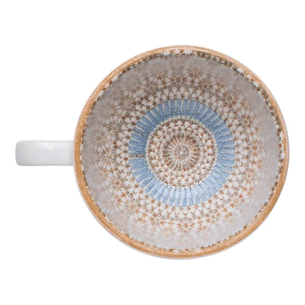 A round porcelain cup with a blue and orange radial geometric design on the interior.
