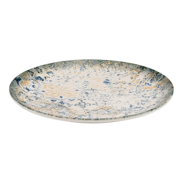 A round blue and white porcelain flat coupe plate with tan accents and an organic foliate design.