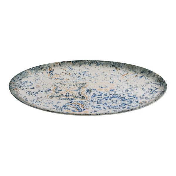 An oval blue and white porcelain platter with tan accents and an organic foliate design.