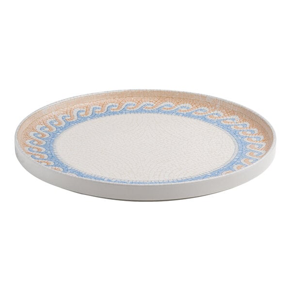 A round white porcelain plate with a raised rim and a blue and tan wave design along the border.