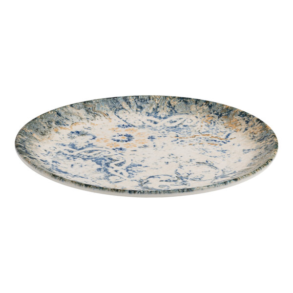 A round blue and white porcelain flat coupe plate with tan accents and an organic foliate design.