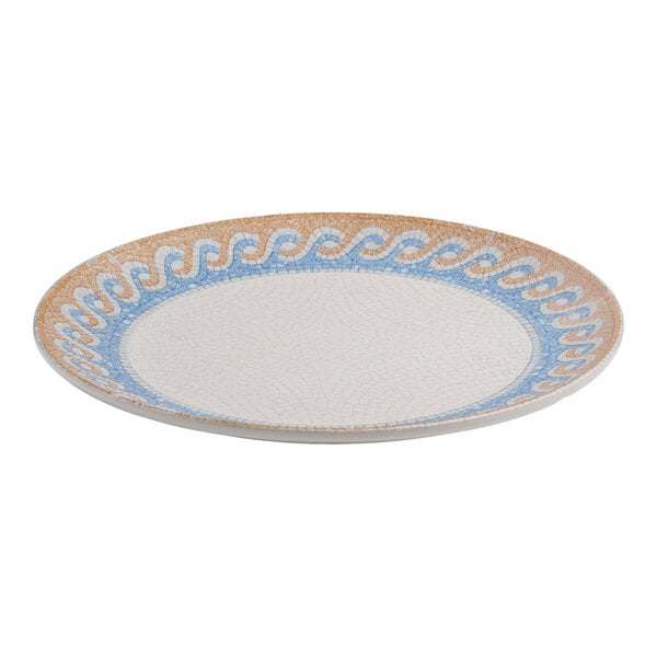A round white porcelain coupe plate with a blue and tan wave design around the rim.