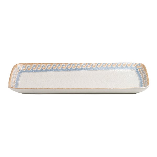 A rectangular white porcelain platter with a blue and tan wave design along the rim.