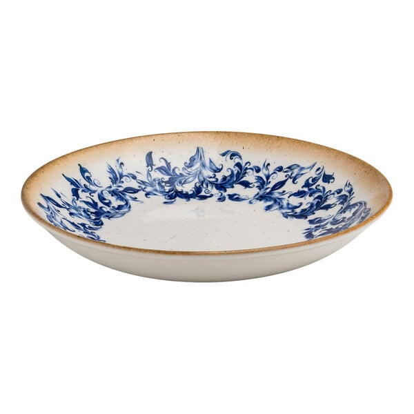 A round white porcelain deep coupe plate with a blue floral center design and a tan rim.