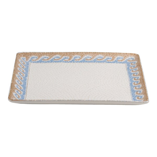 A square white porcelain plate with a blue and tan wave design border.
