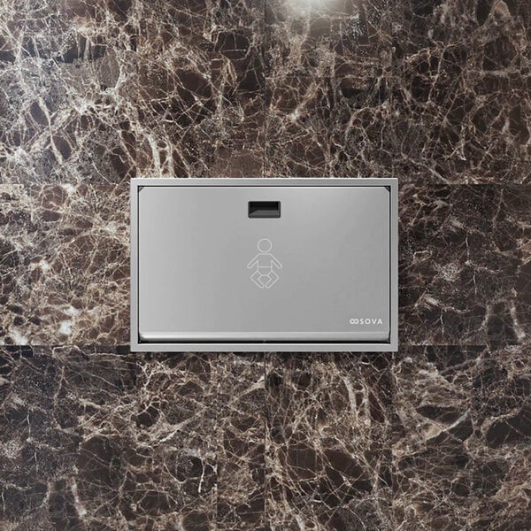 A recessed horizontal stainless steel baby changing station mounted on a marble-patterned wall.