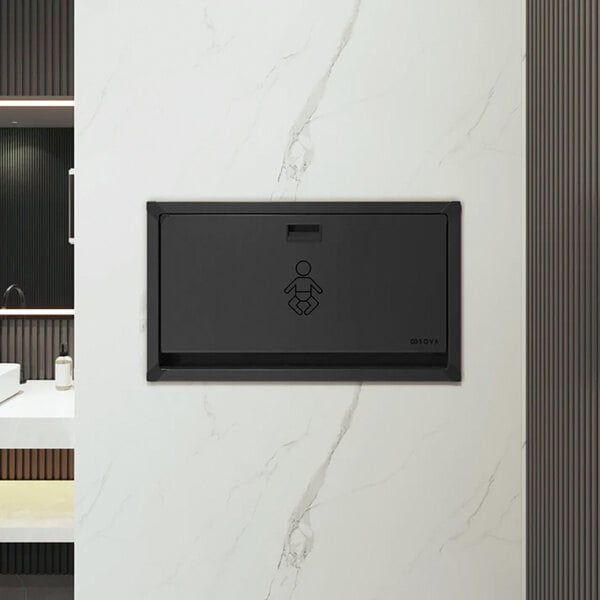 A black stainless steel recessed horizontal baby changing station mounted on a wall.